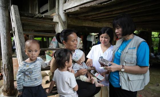 Un miembro del personal de UNICEF entrega alimentos listos para consumir a una familia en Tuyên Quang, Vietnam.